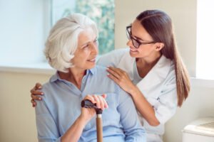 Kind one. Smiling senior woman with her home caregiver CBD FOR RECOVERY